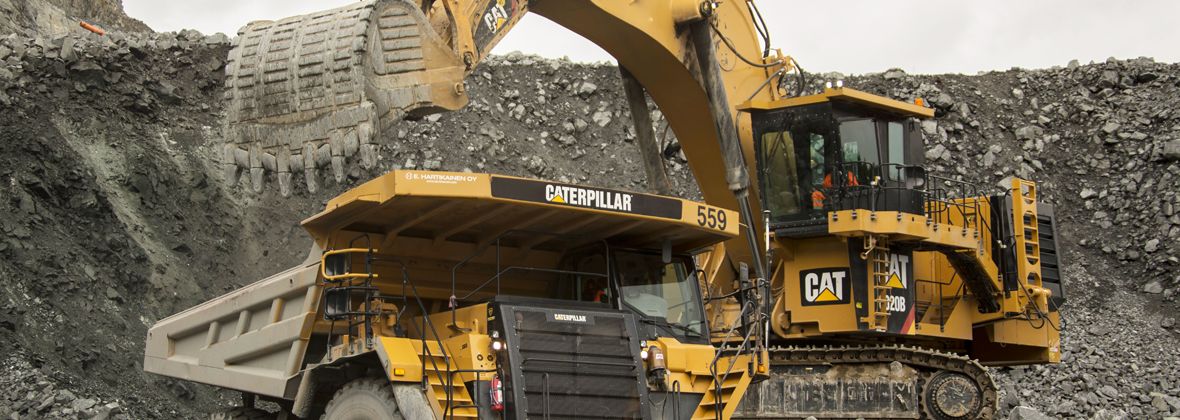 Caterpillar excavator and dump truck in mining operation