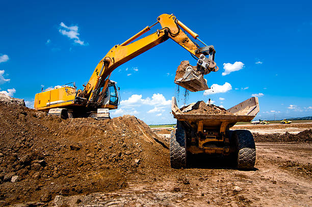 Excavator loading haul truck in daylight